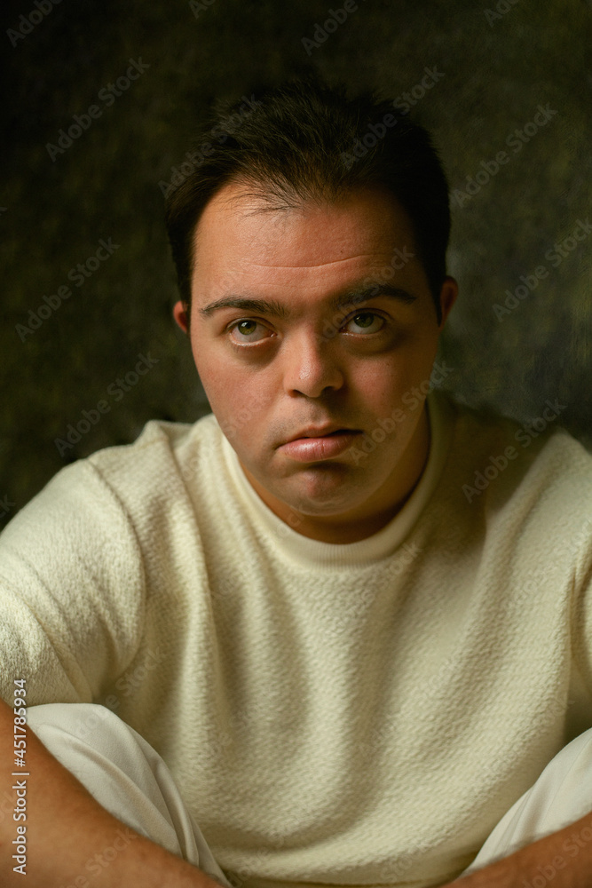 Portrait of young man with Down Syndrome looking into the camera Portrait of young man with Down Syndrome looking into the camera