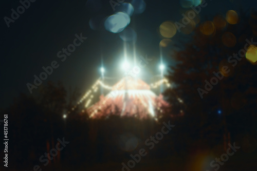 Glowing lights of a big top circus. With a bokeh blurred out of focus edit
