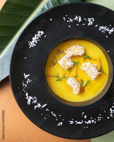 Mango soup. Tropical cuisine on brown backgrounds. Exotic food. Fruit orange soup.