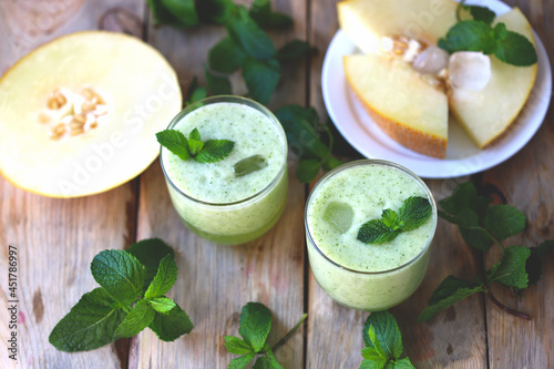 Smoothie melon mint in glasses on a wooden surface. Refreshing detox summer drink.