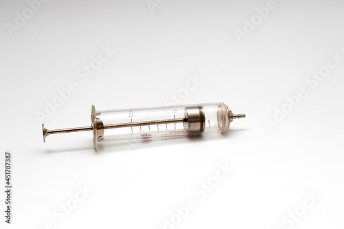 Old glass multiple use syringe without needle. Vintage medical glass syringe