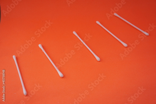 Stock photo of a pile of white cotton buds that are lined up and neatly arranged so that it looks aesthetic. Isolated on an orange background. Medical equipment Industry,design,website photo,Pattern © Kholilulloh