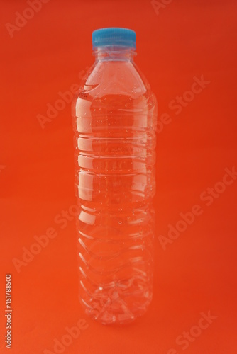 Close up Empty used plastic bottle isolated on an orange background and has a blue cap. For websites, knowledge, news, Recycling, plastic industry
