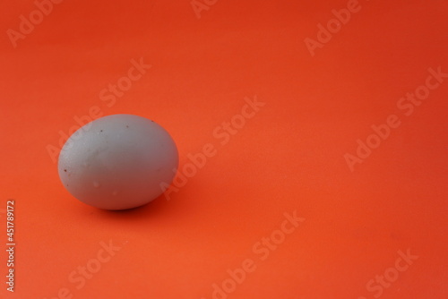 Three chicken eggs from a female hen isolated on an orange background. High protein foods. Suitable for egg business, food, website, health