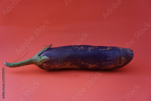 Unripe raw purple eggplant on orange background Fresh vegetables. Space for text. Top view. Natural purple whole eggplant fruit. Copy space. Suitable for vegetables, health care, nutritious food