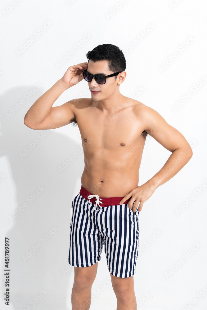 Fototapeta premium Man in striped beach shorts sunbathing.