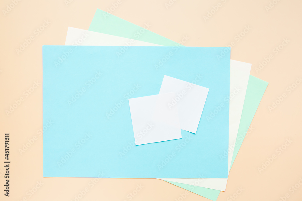 Blank sheets of colored paper, stickers, top view. Blue and beige background for your text, template. Blank sheets of colored paper, stickers, top view. Blue and beige background for your text, template.