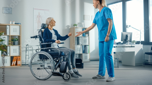 Hospital Physical Therapy: Strong Senior Female Sits on a Wheelchair, Injured Person Successfully Recover, Rehabilitation Physiotherapist Doctors Helps, Assist Disabled Patient