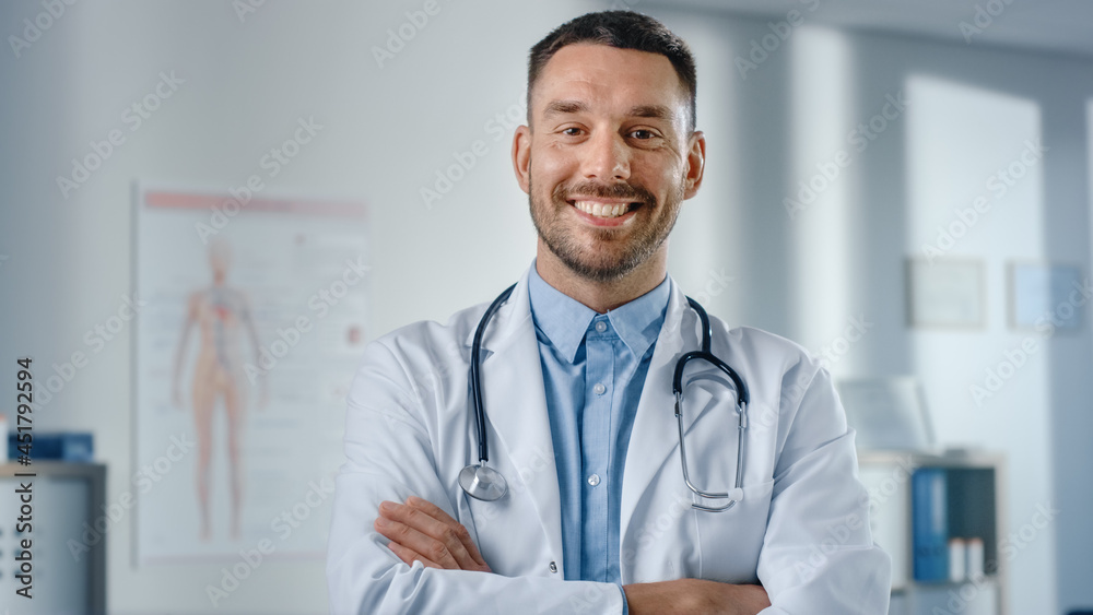 Portrait of Handsome Caucasian Medical Doctor Wearing White Coat and Stethoscope Crosses Arms, Standing in His Health Clinic Office. Successful, Confident Physician Looks at the Camera, Smiles Portrait of Handsome Caucasian Medical Doctor Wearing White Coat and Stethoscope Crosses Arms, Standing in His Health Clinic Office. Successful, Confident Physician Looks at the Camera, Smiles