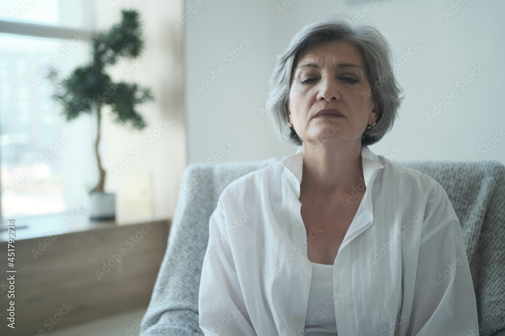 A thoughtful older woman, alone at home considering a dangerous health problem. Upset senior single lady sitting armchair contemplating financial issues, bankruptcy, and loneliness. A thoughtful older woman, alone at home considering a dangerous health problem. Upset senior single lady sitting armchair contemplating financial issues, bankruptcy, and loneliness.