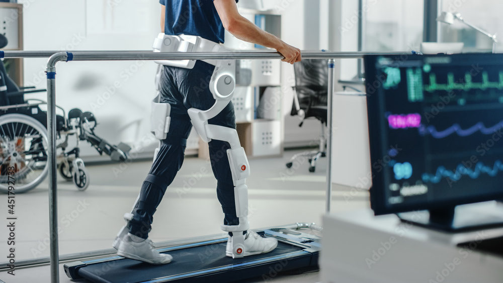 © Gorodenkoff - Modern Hospital Physical Therapy: Patient with Injury Walks on Treadmill Wearing Advanced Robotic Exoskeleton Legs. Physiotherapy Rehabilitation Technology to Make Disabled Person Walk. Focus on Legs © Gorodenkoff - Modern Hospital Physical Therapy: Patient with Injury Walks on Treadmill Wearing Advanced Robotic Exoskeleton Legs. Physiotherapy Rehabilitation Technology to Make Disabled Person Walk. Focus on Legs