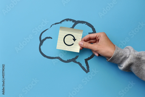A silhouette of the brain and a sticker with the image of the reboot icon. A symbol of a break in the work of thinking photo