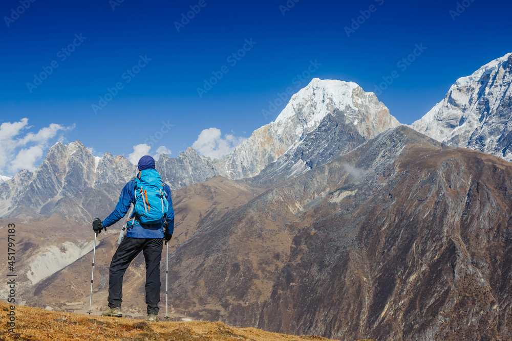 Active hiker hiking, enjoying the view, looking at Himalaya mountains landscape. Travel sport lifestyle concept