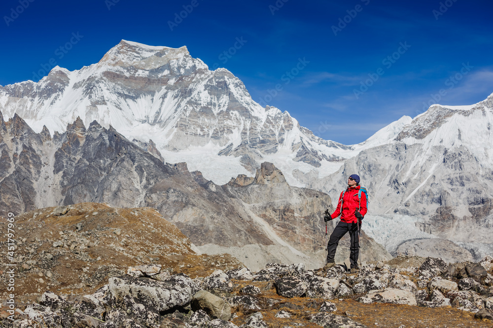 Active hiker hiking, enjoying the view, looking at Himalaya mountains landscape. mountaineering sport lifestyle concept