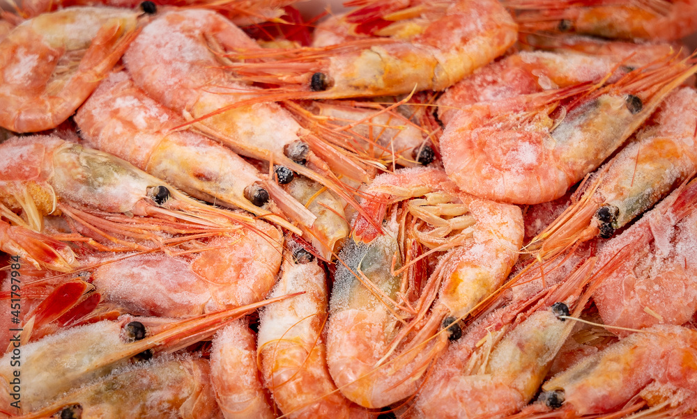 Pre-boiled and frozen northern shrimp. Close-up view from above. Background or texture