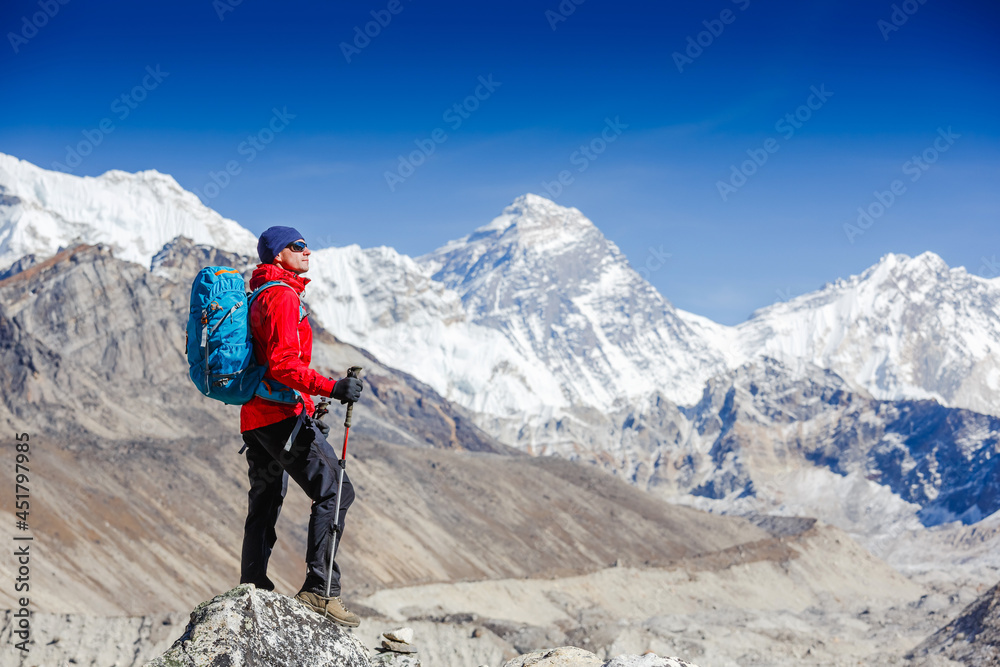 Hiking in Himalaya mountains. Young man with backpack enjoying Everest view