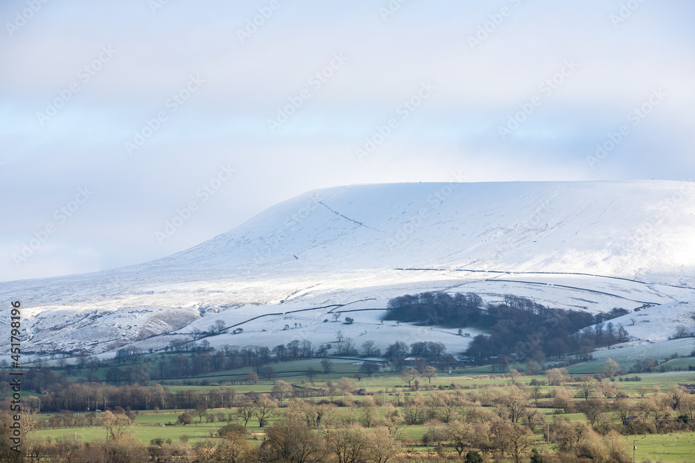 Obraz premium Snowy mountain covered in fresh winter snow. View of Pendle hill in the ribble valley, lancashire