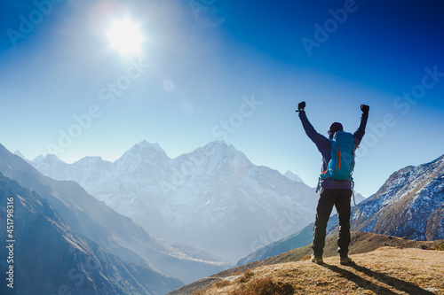 Hiker cheering elated and blissful with arms raised in the sky after hiking. Everest base camp trek