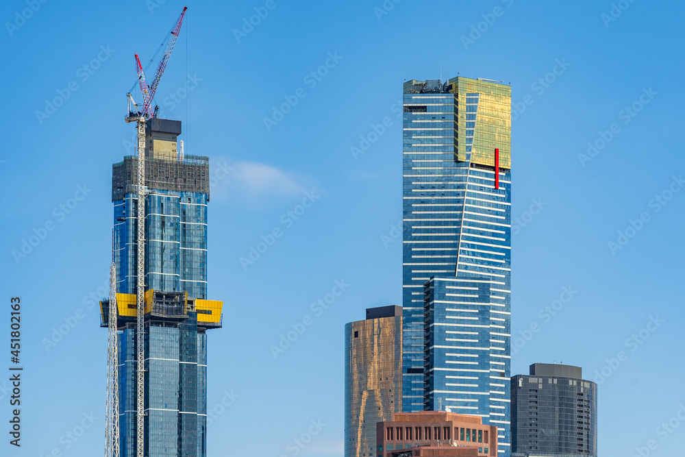 Horizontal shot of two high rise building, one under construction in ...