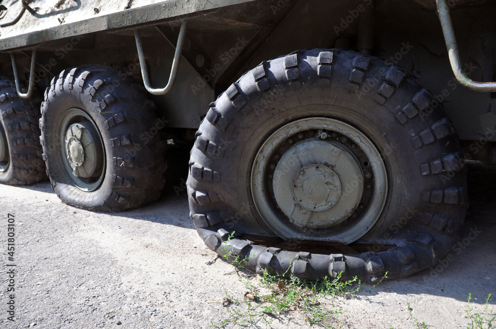 A flat tire on a voyengoy vehicle. Military padded Soviet armored personnel carrier A flat tire on a voyengoy vehicle. Military padded Soviet armored personnel carrier