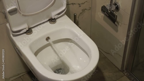 Toilet bowl with bidet. Water sprays from toilet bowl.