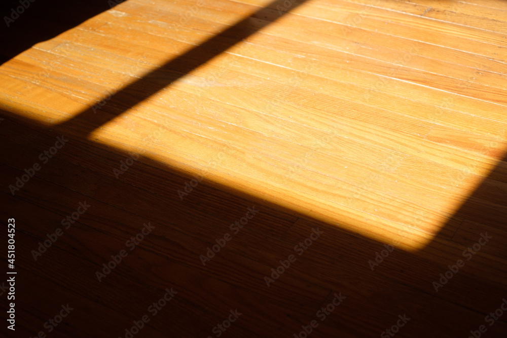 Sunlight and shadows fall on a freshly installed pine floor Sunlight and shadows fall on a freshly installed pine floor