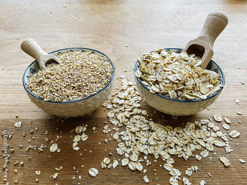 Steel cut / pinhead oats vs rolled oats in bowls with wooden scoops