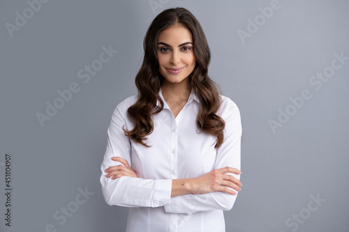 Happy confident business woman smile holding arms crossed grey background, confidence