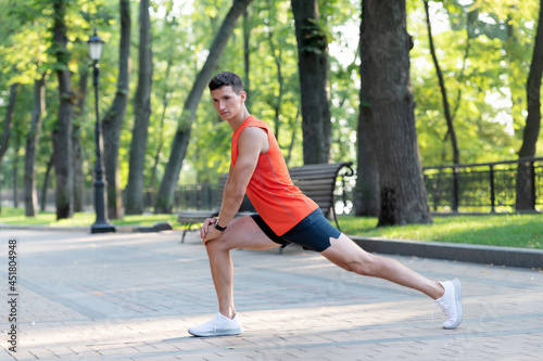 Warming up before workout. Fit guy hold lunge position. Man do warm-up exercises. Warm-up activities