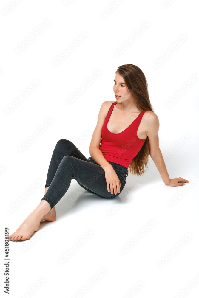 Funny woman in tank-top and jeans sits on a floor
