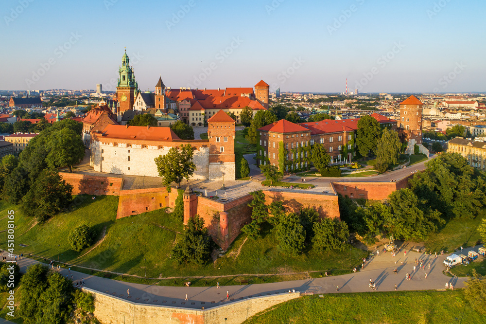 Krakow, Poland. Historic royal Wawel castle and cathedral. Aerial view at sunset in summer.  Park, promenades and walking people