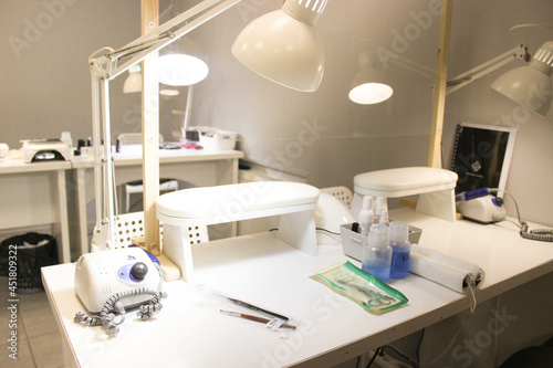Interior of a nail care studio. White room for a manicure with a lamp and a tool  a ready-made place for a manicurist
