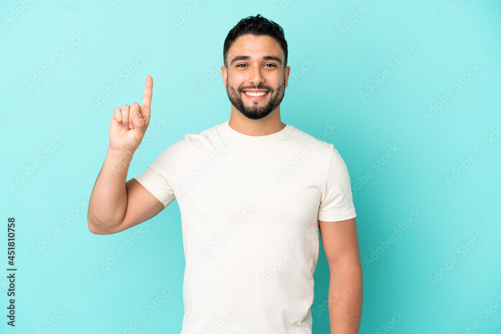 Young arab man isolated on blue background pointing up a great idea Young arab man isolated on blue background pointing up a great idea