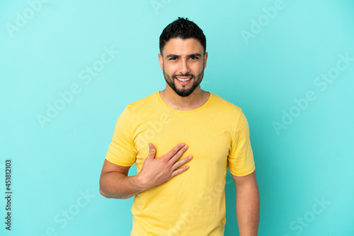 Young arab man isolated on blue background pointing to oneself