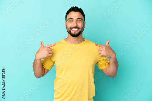 Young arab man isolated on blue background giving a thumbs up gesture