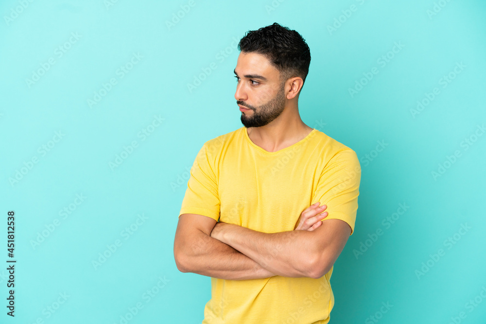 Young arab man isolated on blue background keeping the arms crossed Young arab man isolated on blue background keeping the arms crossed
