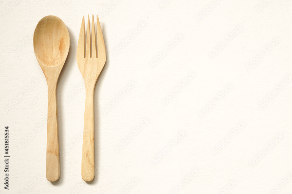 top view of wooden cutlery placed on beige background with copy space. top view of wooden cutlery placed on beige background with copy space.