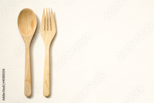 top view of wooden cutlery placed on beige background with copy space.