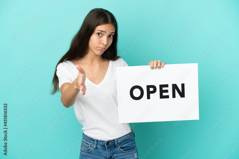 Young French woman isolated on blue background holding a placard with text OPEN making a deal Young French woman isolated on blue background holding a placard with text OPEN making a deal
