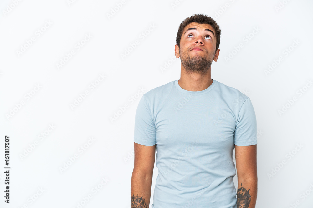 Young handsome Brazilian man isolated on white background and looking up
