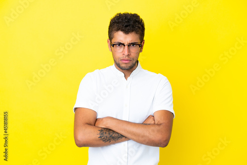 Young handsome Brazilian man isolated on yellow background with unhappy expression