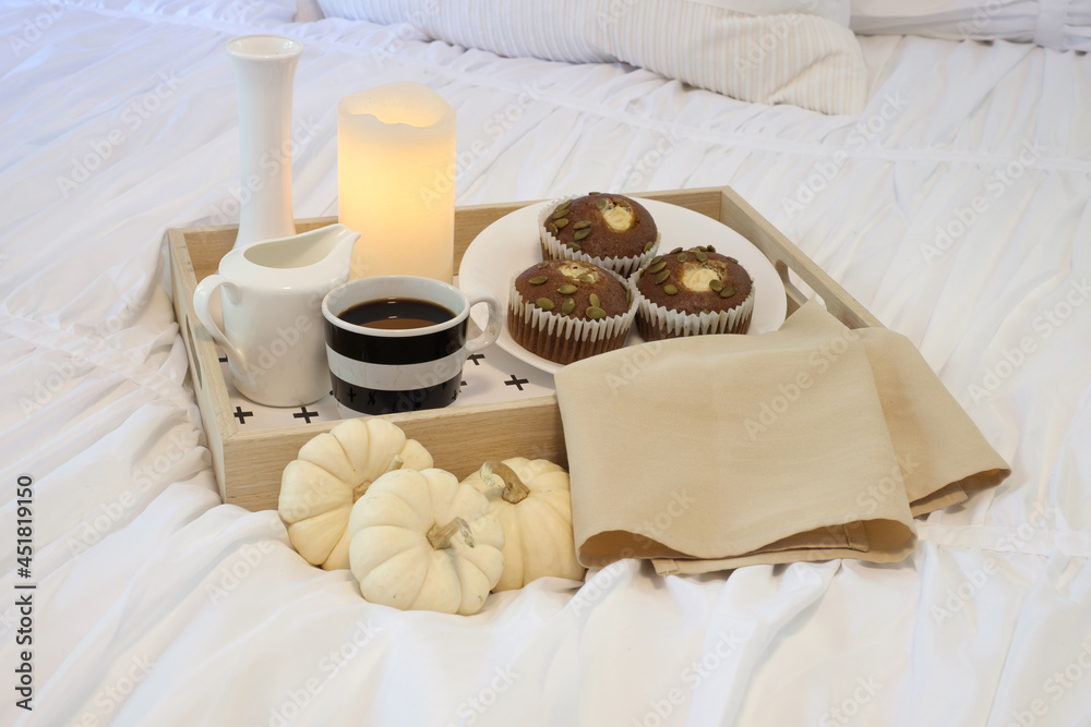 A food serving tray sits on a bed in a beautiful bedroom setting in the morning. A food serving tray sits on a bed in a beautiful bedroom setting in the morning.