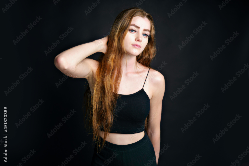 Beautiful young redhead girl with attitude a portrait on black background Beautiful young redhead girl with attitude a portrait on black background