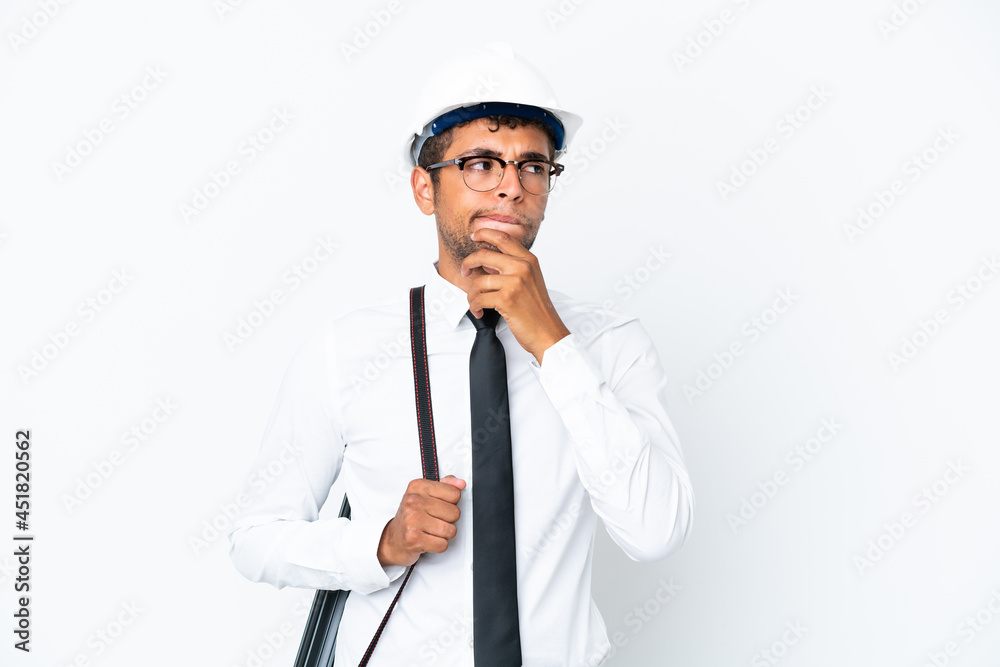 Architect brazilian man with helmet and holding blueprints having doubts and thinking