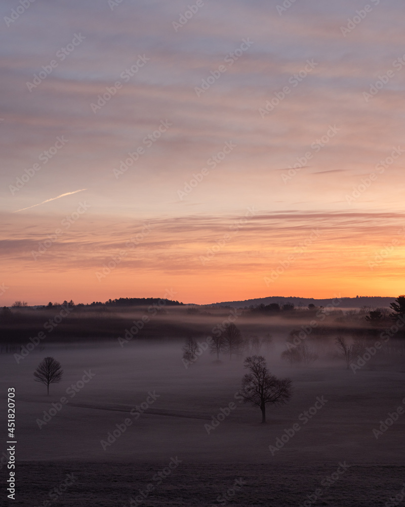 Sunrise over a foggy field