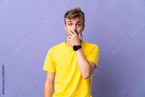 Young handsome blonde man isolated on purple background surprised and shocked while looking right