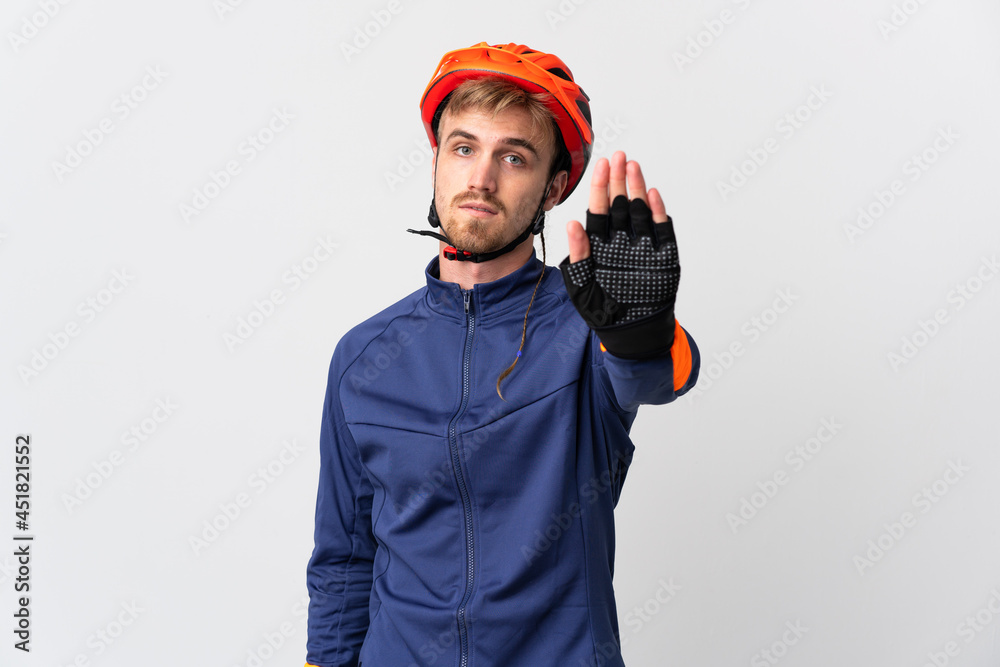 Young cyclist blonde man isolated on white background making stop gesture - obrazy, fototapety, plakaty 