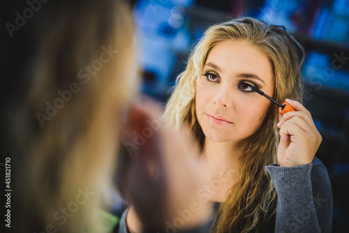 Cute Girl In Front Of Mirror Applying Mascara