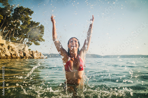 Woman Having Fun At The Beach With Arms Raised