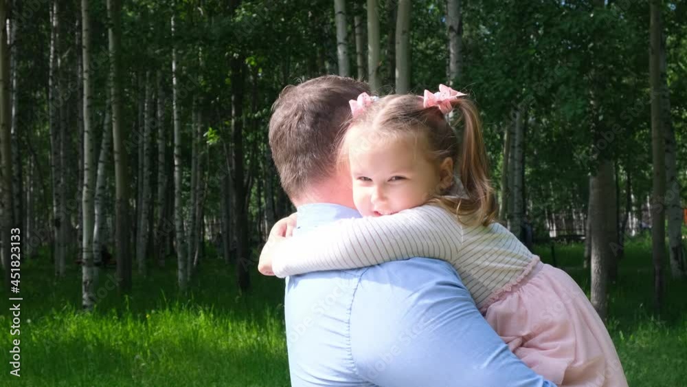 Happy father carrying around his neck and hugging daughter 4-5 years old while walking in the park Happy father carrying around his neck and hugging daughter 4-5 years old while walking in the park